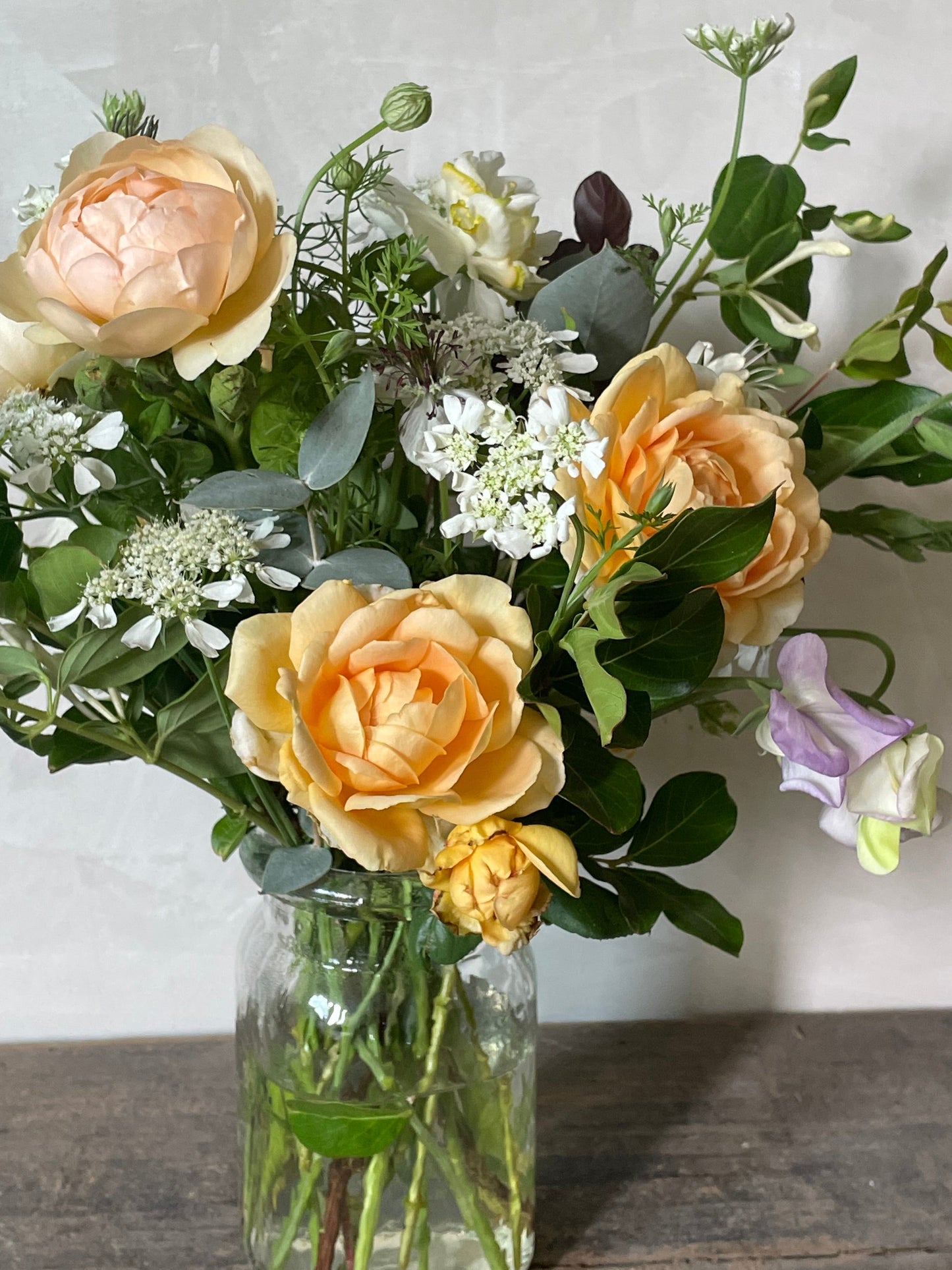 Bouquet of flowers with a clear vase on a marble surface